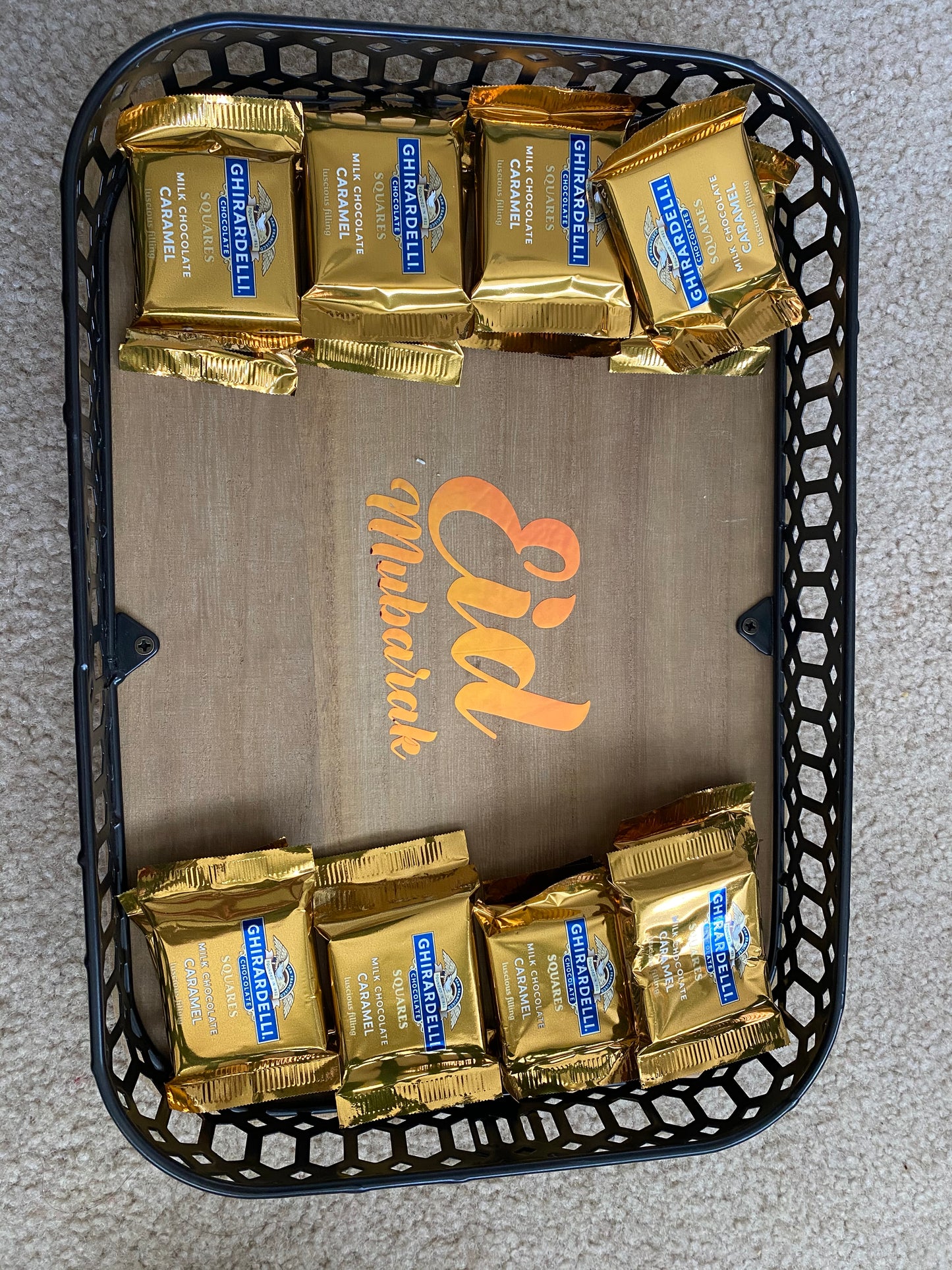 Basket with Ghirardelli chocolate bars and 'Eid Mubarak' card on a gray surface