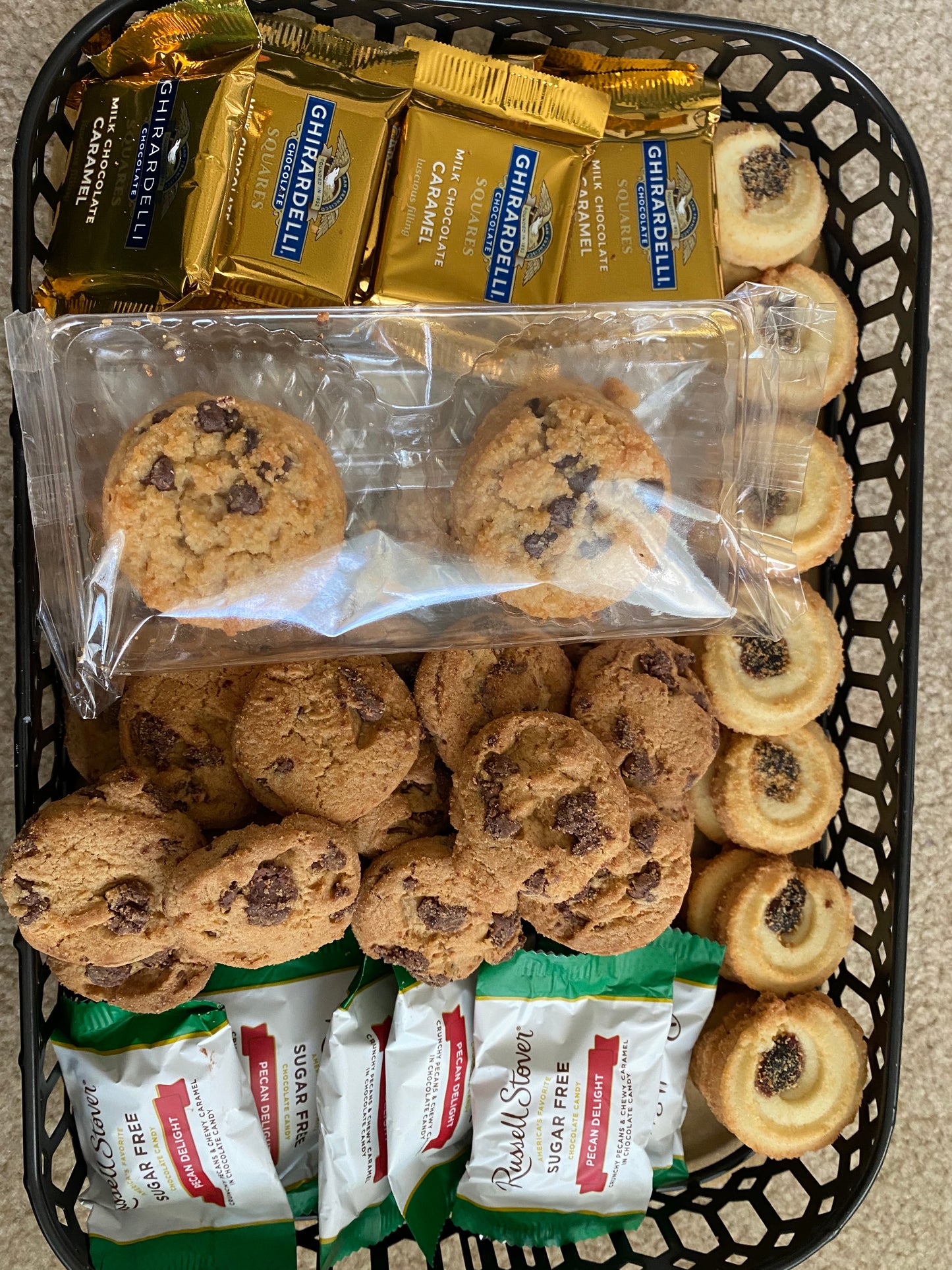 Basket filled with cookies, chocolate bars, and small packets of tea.